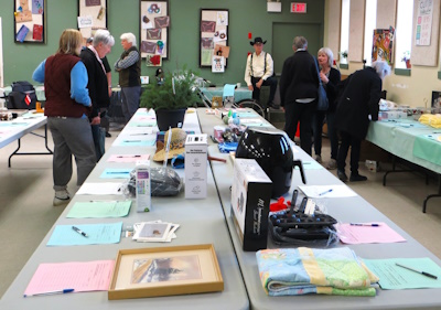 People looking around at items on silent auction tables.