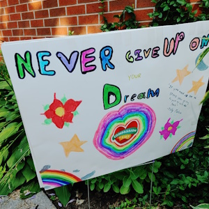 A creative bristol board poster with the words Never Give Up emblazoned across it