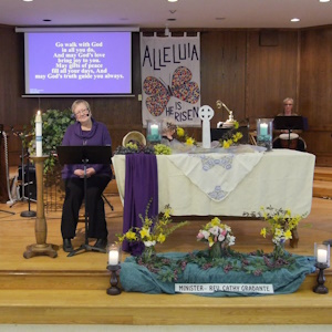 Rev Cathy Gradante seated at front of curch on Sunday morning